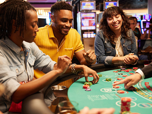 a group smiling and playing blackjack in a Boyd casino